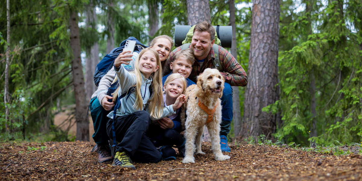 Familie på tur i skogen – med mobiler