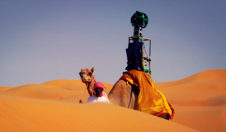 Kamel og fører med trekker i ørkene