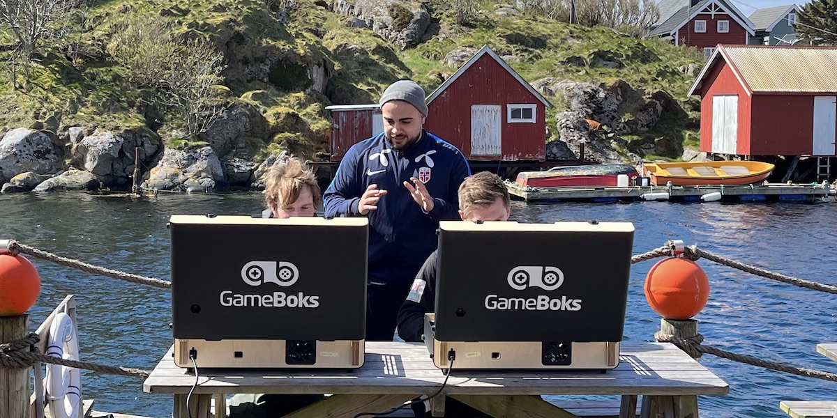 Tre personer spiller eFotball med 5G utendørs på Mausund
