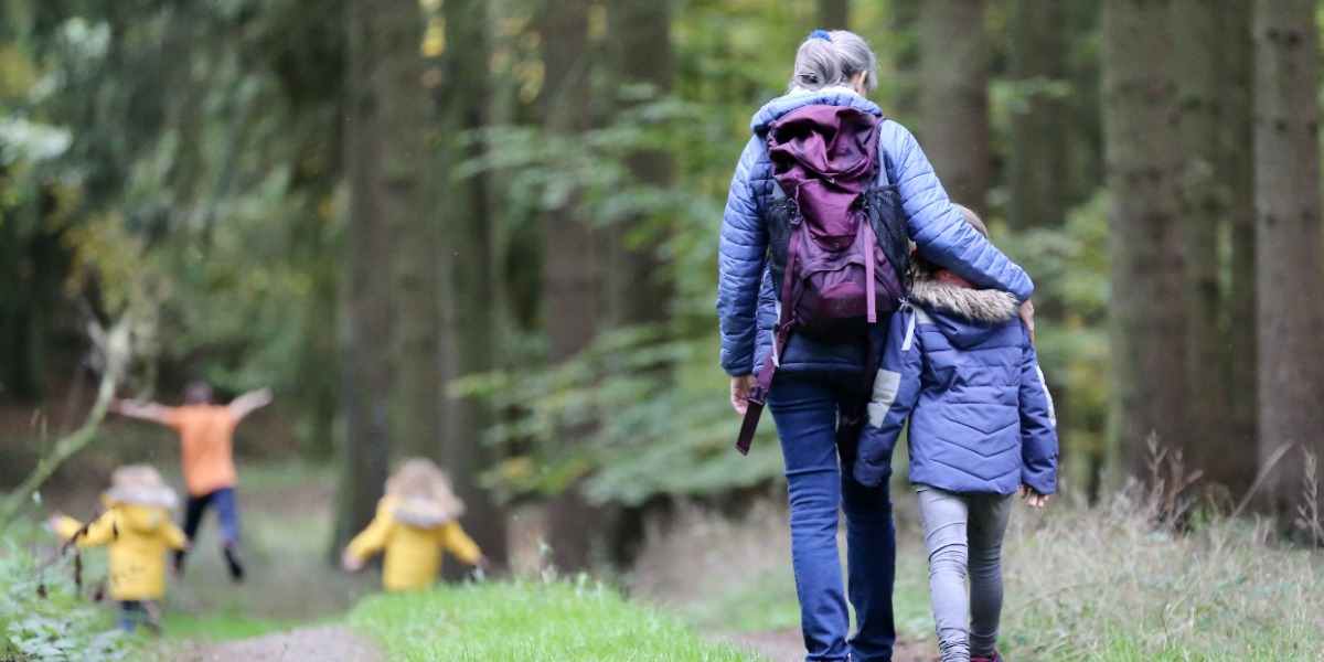 Bilde av mor og datter som går tur i skogen