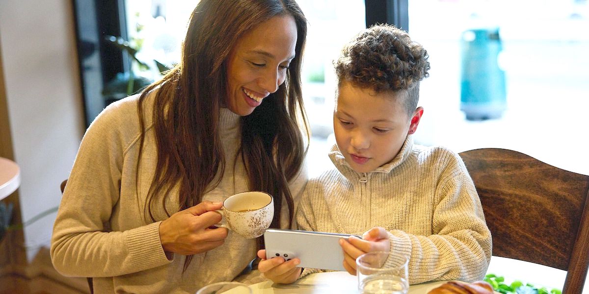 Mor og sønn med mobil på kafé