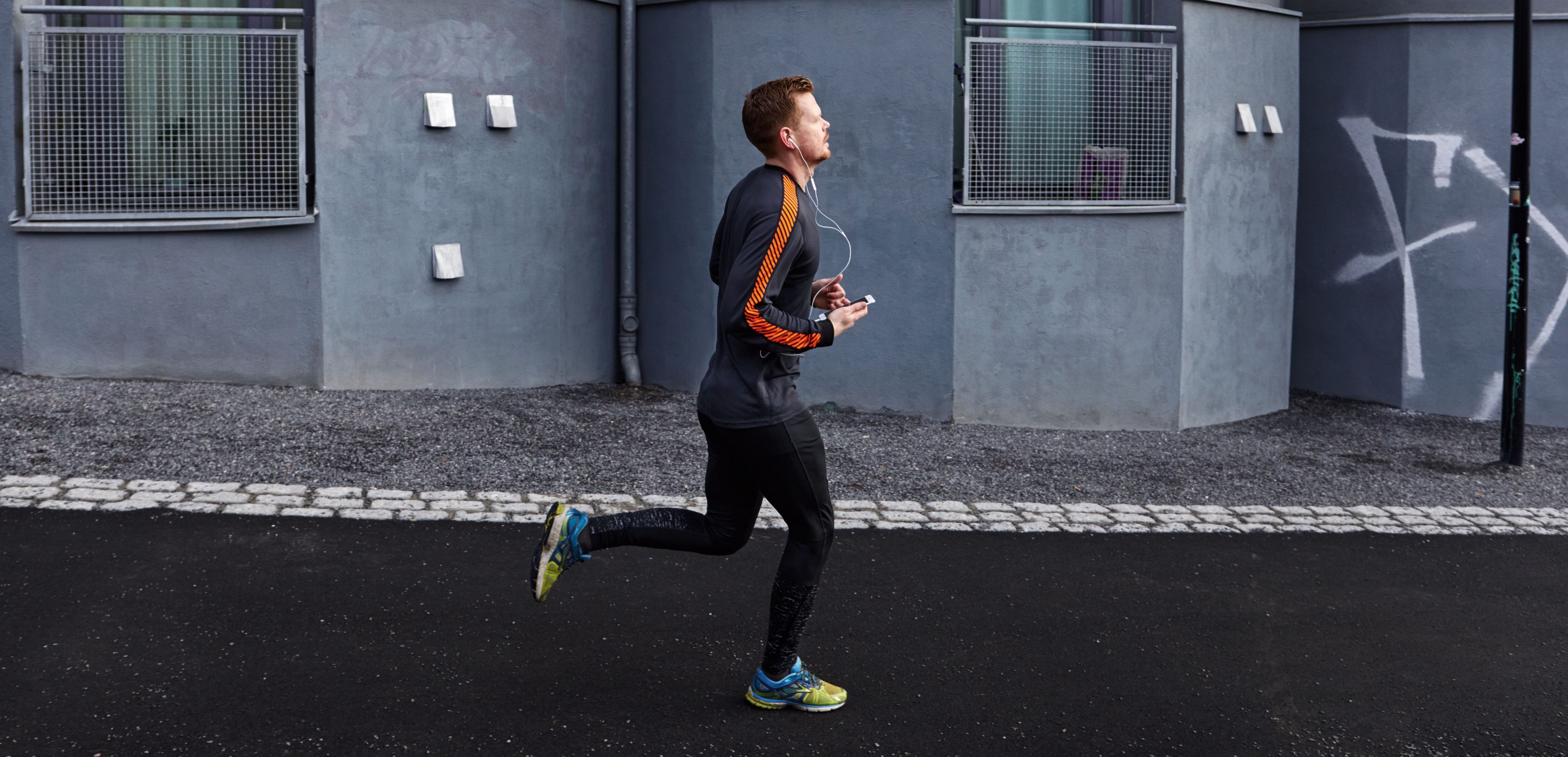 Mann som jogger med mobil og ubegrenset data