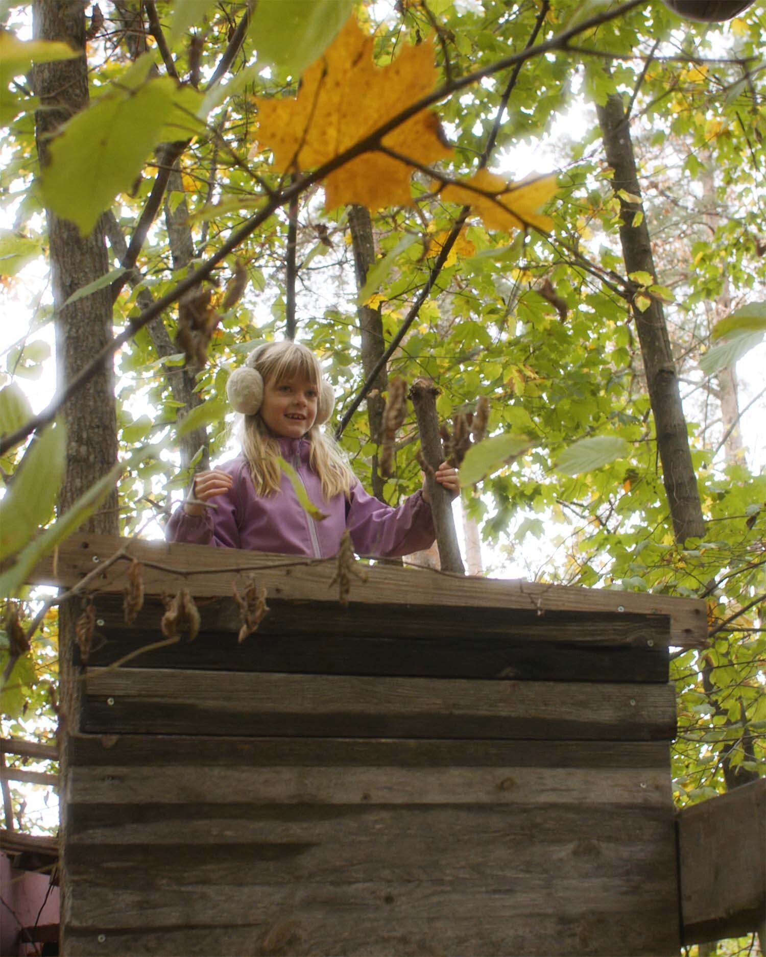 Bilde av liten jente i trehytte i skogen