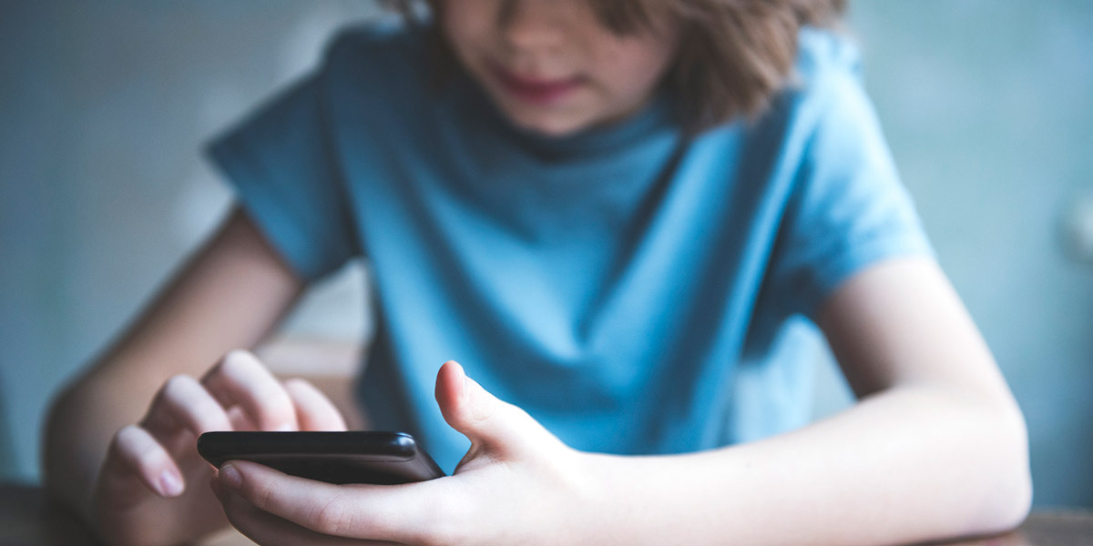Nettvett for skolebarn – gutt holder mobil, og her er rådene til deg som forelder