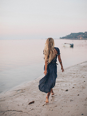 Bilde av kvinne som går på en strand