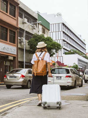kvinne med koffert i by